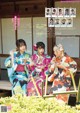 A group of women in kimonos sitting on a bench.