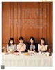 A group of women sitting at a table with plates of food.