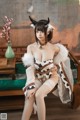 A woman in a cow costume sitting on a couch.