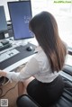 A woman sitting at a desk in front of a computer.