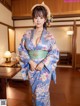 A woman in a blue kimono posing for the camera.