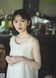 A woman in a white dress standing in a room.