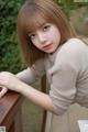 A young woman leaning on a wooden railing.